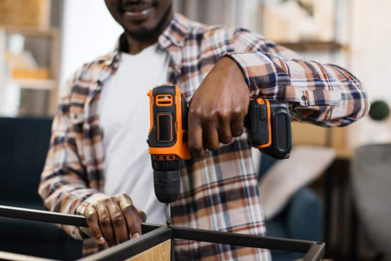 African american man assembling furniture at home